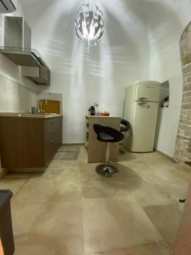 a kitchen with a chair and a refrigerator at De Cristoforis in Terlizzi