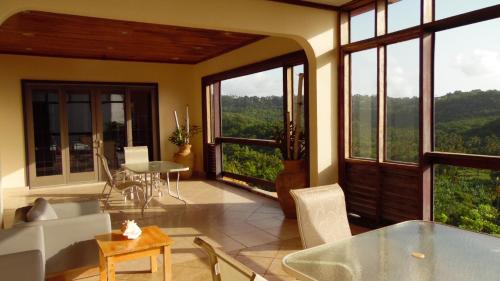un soggiorno con tavolo, sedie e finestre di Vacation Suites a Micoud