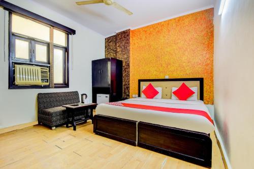 a bedroom with a bed and a chair in it at OYO Hotel Delhi Darbar in New Delhi