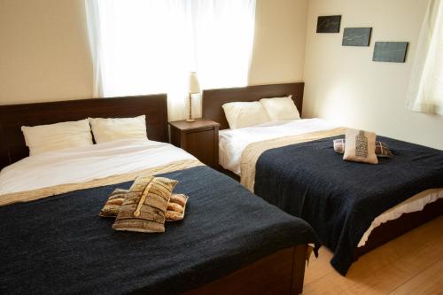 two beds in a hotel room with towels on them at Relax Lounge TOKYO in Tokyo