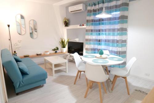 un salon avec une table et un canapé bleu dans l'établissement SIKELIA Apartment, à Caltagirone