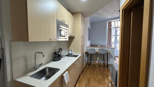uma cozinha com um lavatório e um balcão em Moderno estudio en Porta Do Sol em Vigo