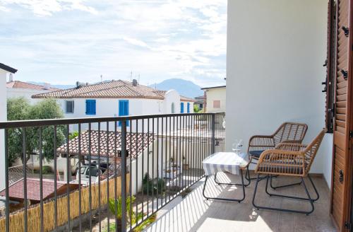 a balcony with two chairs and a table at Dommu Livia in Lotzorai