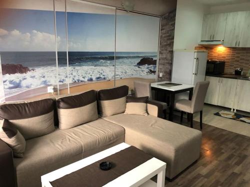 a living room with a couch and a view of the ocean at Sunshine apartman in Belgrade