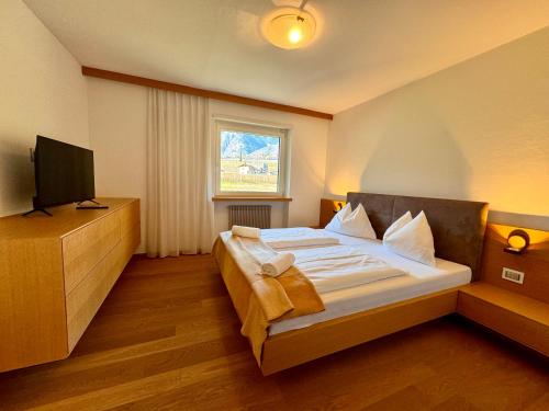 een slaapkamer met een groot bed en een tv. bij Apartment Steinach in Lagundo