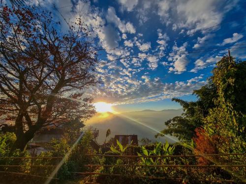 大吉嶺的住宿－Peace Valley German Heritage Cottage Home Stay，享有日落和山脉美景