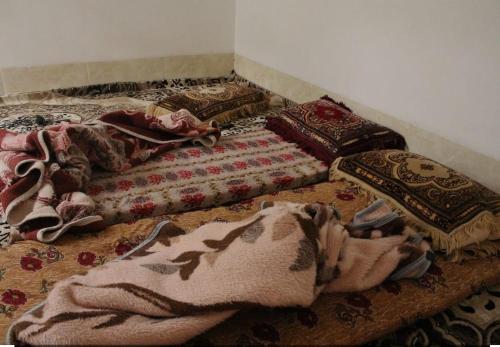 een kamer met verschillende kussens en dekens op de vloer bij النخلة in Erfoud