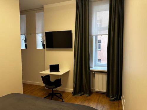 a bedroom with a desk and a bed and a window at Stylish studio in the heart of Riga in Rīga