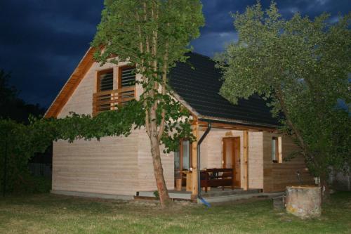 a small house with a tree in front of it at Agroturystyka Łazory nad Tanwią 