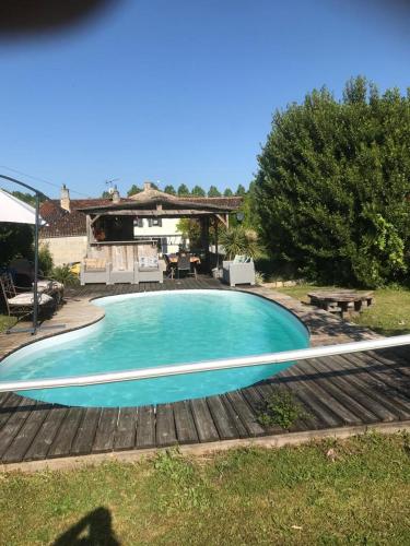 une piscine bleue avec une table et un banc dans l'établissement La Lavande, à Nuaillé-sur-Boutonne