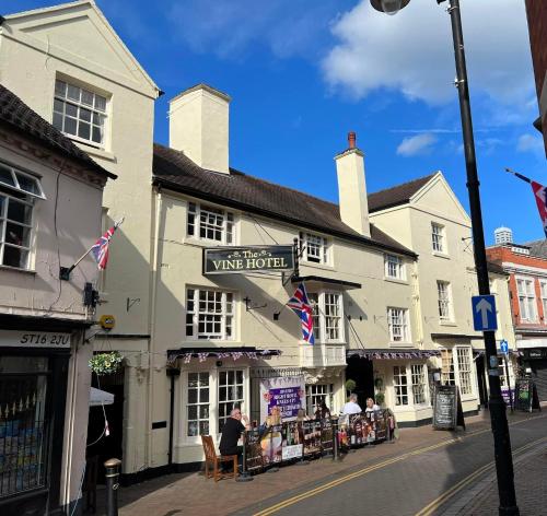 a group of buildings on a street with people sitting outside at The Vine hotel by THEGREATVINE Ltd in Stafford