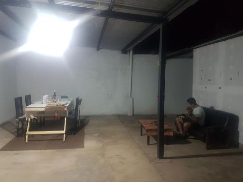 a man sitting on a bench in a room at Casa Hogar in Monterrico