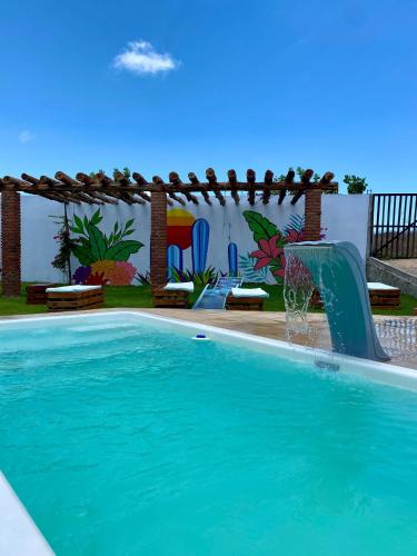 a swimming pool with a water slide in a yard at Pousada Delta Village in Tutóia