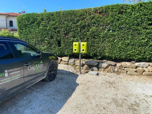 a car parked next to a yellow sign next to a hedge at Agriturismo Campallegro in Cecina