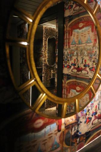 a mirror reflecting a room with a painting on the wall at Hotel Casa Palacete Tablas by Maxi Hoteles in Granada