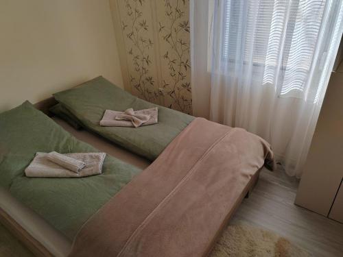 1 dormitorio con 2 camas individuales y toallas. en Apartman Stanimirović, en Zajecar