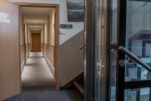 a hallway in a building with a door open at Pension Böhmerwald in Železná Ruda