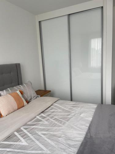 a bed with sliding glass doors in a bedroom at Luxury one bedroom flat in Harrow in Harrow