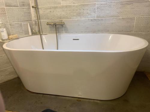 a white bath tub sitting in a bathroom at appartement de charme centre historique de Brive in Brive-la-Gaillarde