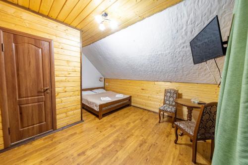 a room with a bed and a table and a door at Готель Поляницький in Bukovel