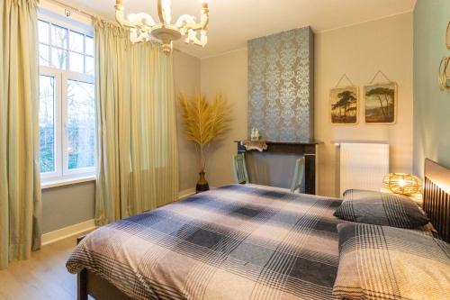 1 dormitorio con cama y lámpara de araña en Sweet Alice Holiday Home, en Ypres
