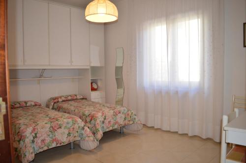 two beds in a small room with a window at Mary's Dream - Villa overlooking Capri and Ischia in Sorrento Peninsula in Massa Lubrense