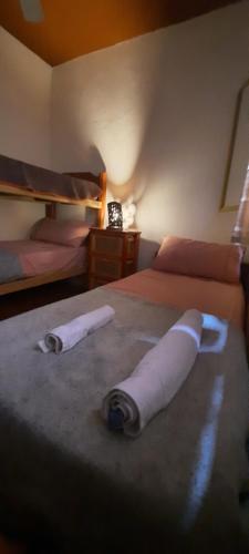 1 dormitorio con 2 camas y toallas en la cama en Montañas Del Sol en Santa Rosa de Calamuchita