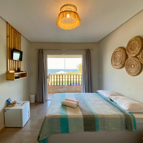 a bedroom with a bed with a view of the ocean at Pousada Delta Village in Tutóia