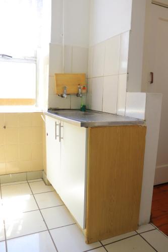 eine Küche mit weißen Schränken und einem Waschbecken in der Unterkunft Grandborough in Durban