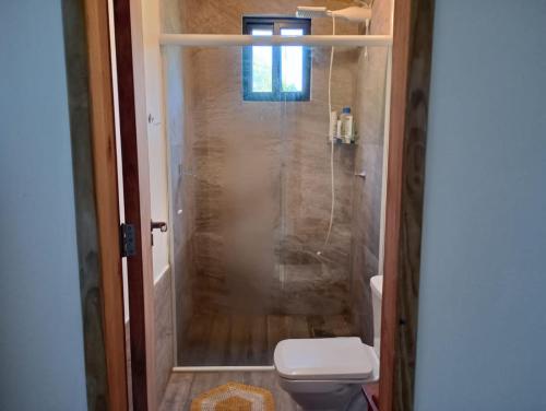 Un baño con ducha y un inodoro. en Morada da Laika, en Praia do Rosa