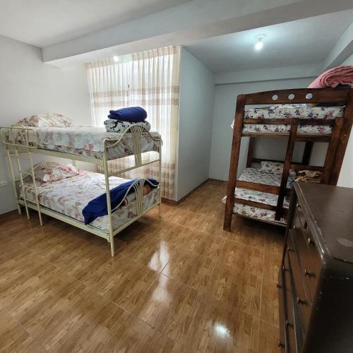 a bedroom with two bunk beds and a wooden floor at Apartamento viaje de estudio in Huancayo