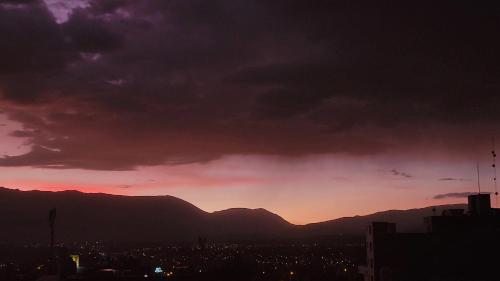 a sunset over a city with mountains in the background at Apartamento viaje de estudio in Huancayo