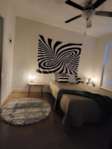 a bedroom with a bed with a black and white painting on the wall at Quaint one bedroom apartment in Greensboro