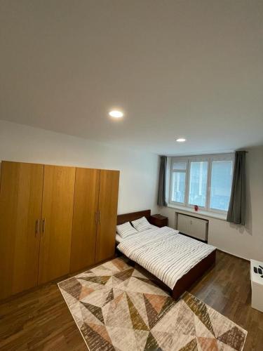 a bedroom with a large bed and wooden cabinets at Luxury 2bed flat with free parking in Bratislava
