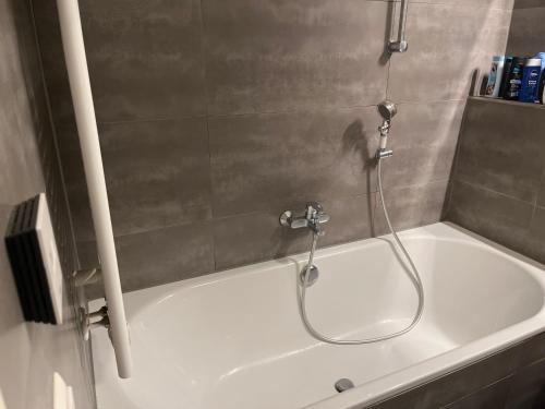 a white bath tub with a shower in a bathroom at Beautiful apartment for you in Ulm