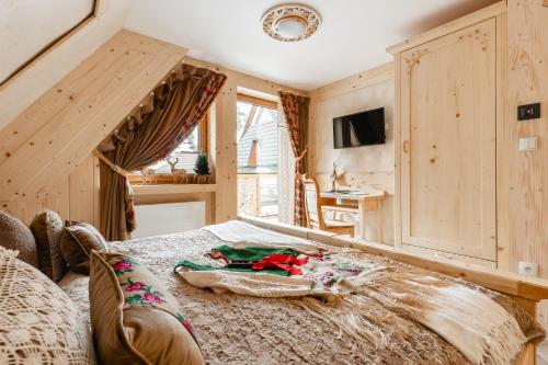 a bedroom with a bed and a desk in a room at Brzozowa Osada - Premium Chalets Zakopane in Zakopane