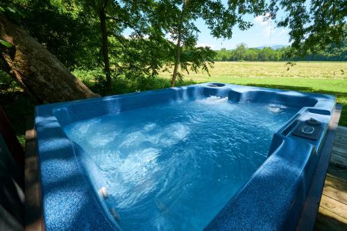 a large blue hot tub sitting next to a tree at Creekwalk Inn Bed and Breakfast with Cabins in Cosby