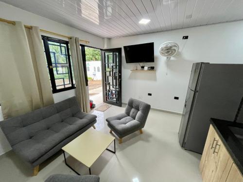 uma sala de estar com um sofá e cadeiras e uma televisão em HOTEL TORRE DELUXE ¨SANTORINI¨ em Doradal