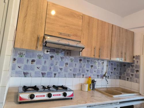a kitchen with a stove and wooden cabinets at Spacious 3 room apartment Prime Location on 2nd Floor with proximity to all amenities in Sfax