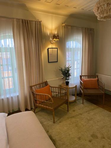 a bedroom with two chairs and a table and windows at HOUSE KA TEKKE ROOM in Canakkale
