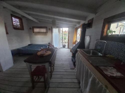 eine Küche mit einem Tisch und einem Waschbecken in einem Zimmer in der Unterkunft El Descanso in Neptunia
