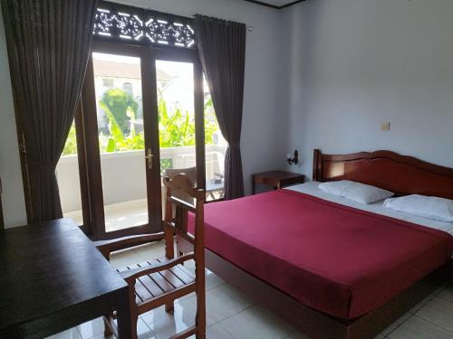- une chambre avec un lit et une grande fenêtre dans l'établissement Celagi Inn, à Padangbai
