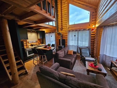 a living room with a couch and chairs and a kitchen at Orino Livadi Chalet II in Arachova