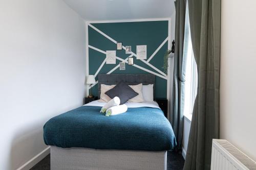 a bedroom with a blue bed with a blue blanket at The Blue House by Luke Stays in Bearpark