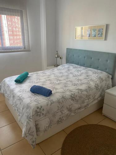 ein Bett mit zwei Kissen darauf in einem Schlafzimmer in der Unterkunft Playa Valencia Residencial Sol y Mar Terraza con Vistas y Parking in Playa Pobla de Farnals