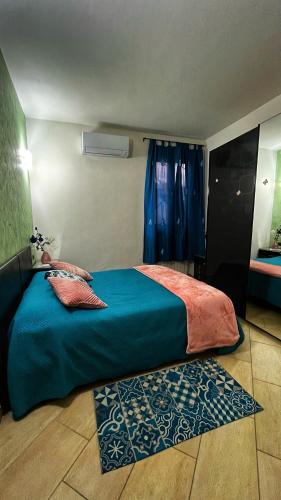 a bedroom with a bed with blue sheets and a window at La Palma apartment in Vigevano