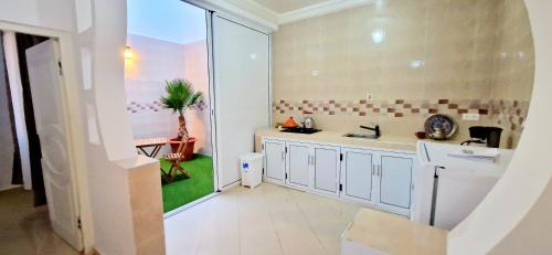 une grande cuisine blanche avec un évier et une fenêtre dans l'établissement Beach Appartment close to Marina 105 sqm, à Agadir