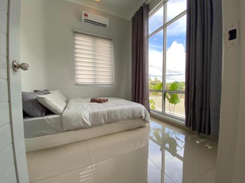 ein Schlafzimmer mit einem Bett und einem großen Fenster in der Unterkunft Homestay Sekinchan with Private Pool in Sekinchan