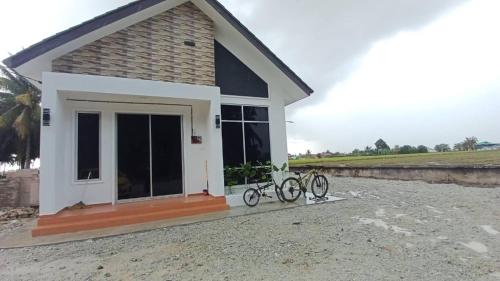 ein Haus mit zwei Fahrrädern, die draußen geparkt sind in der Unterkunft Homestay Sekinchan with Private Pool in Sekinchan