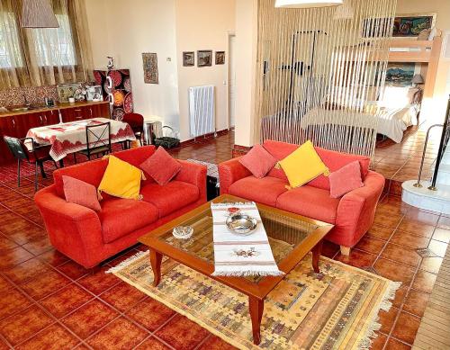 a living room with two red couches and a coffee table at Modus Operandi in Kavála